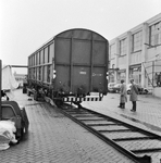 168032 Afbeelding van het plaatsen van een goederenwagen type Hbis van de N.S. op een oplegger van een vrachtauto ( ...